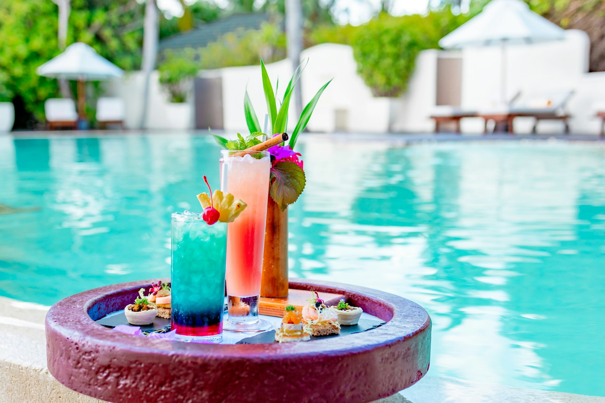 served floating tray in swimming pool with drinks and snacks on tropical island resort in Maldives,